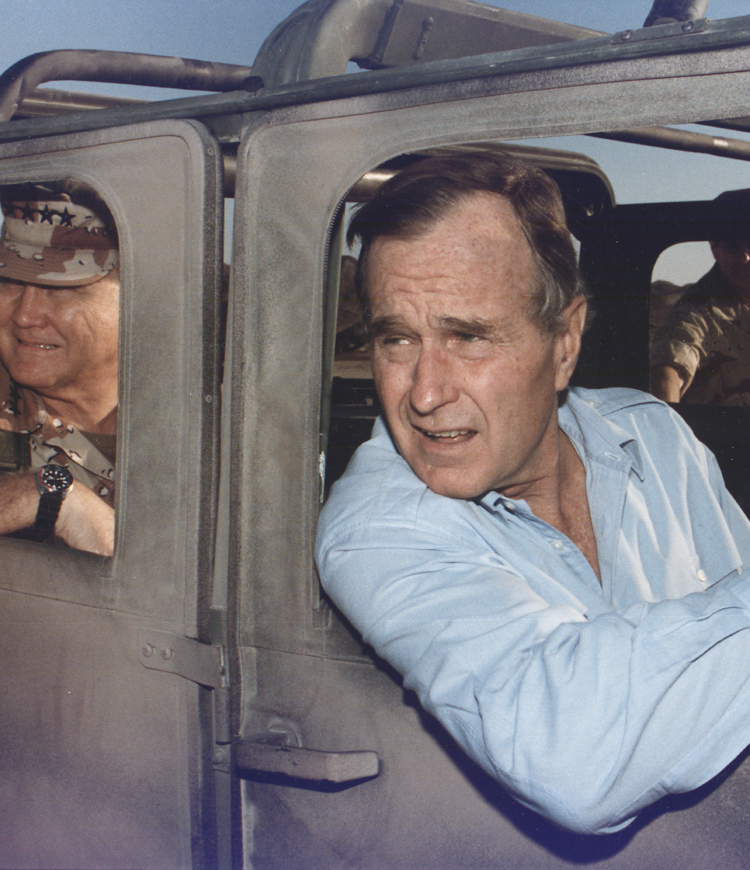 President George H.W. Bush rides in a HUMVEE with General H. Norman Schwarzkopf during his visit with troops in Saudi Arabia on Thanksgiving Day